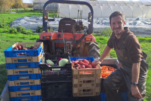 un agriculteur sur son tracteur avec des légumes